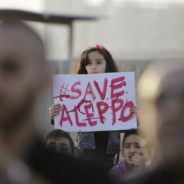 A Syrian girl holds a placard during a rally in solidarity with Aleppo, in the Lebanese northern port city of Tripoli, on May 1, 2016. More than a week of fighting in Syria's second city has killed hundreds of civilians and left a UN-backed peace process hanging by a thread. Concern has been growing that the fighting in Aleppo will lead to the complete collapse of a landmark ceasefire between President Bashar al-Assad's regime and non-jihadist rebels that was brokered by Moscow and Washington. / AFP PHOTO / IBRAHIM CHALHOUB